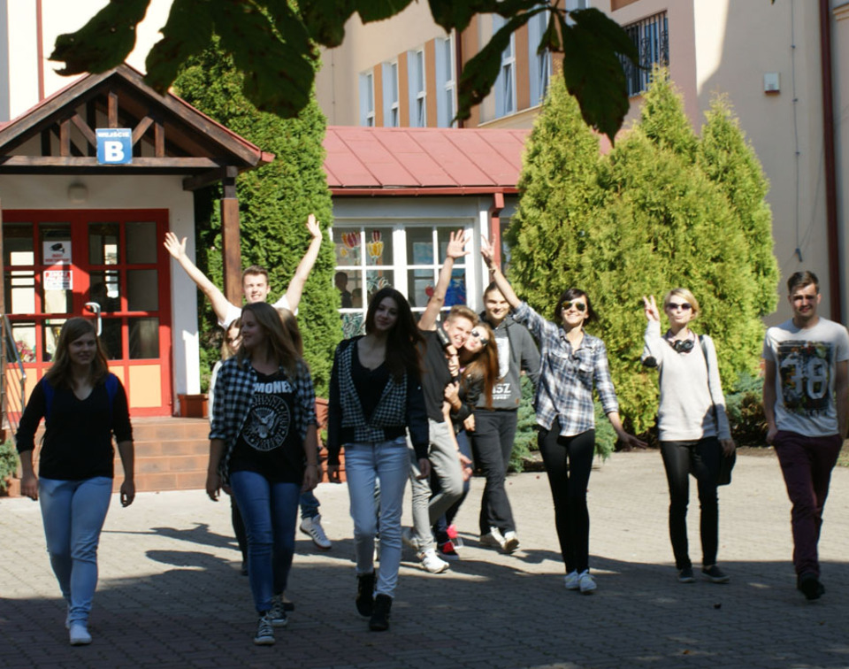 uczniowie przed budynkiem szkoły